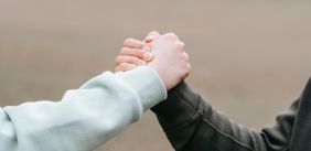 Twee mensen houden elkaars hand vast